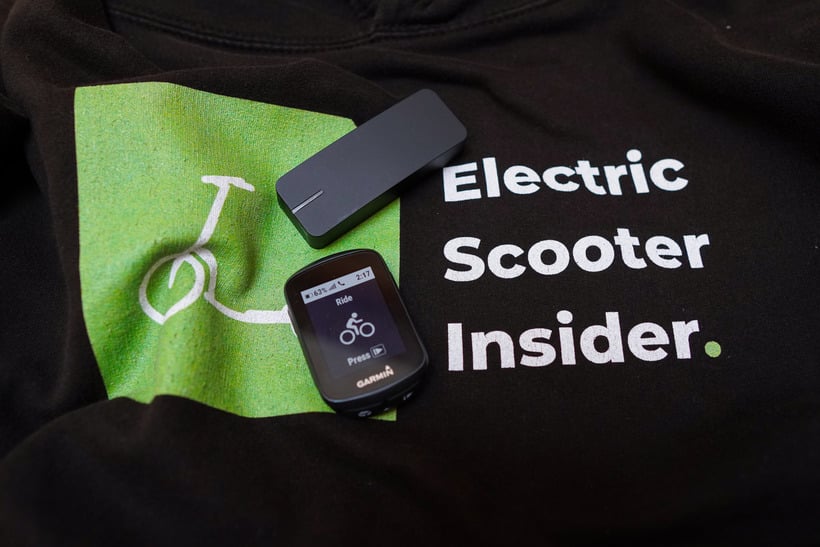 Electric Scooter Testing Equipment - Dragy GPS Performance Box & Garmin Edge 130 Plus Resting On An Electric Scooter Insider Hoodie